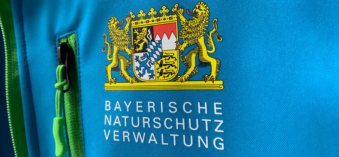Das Bild zeigt Das Logo und die Erkennungsfarben der Bayerische Naturschutzverwaltung.